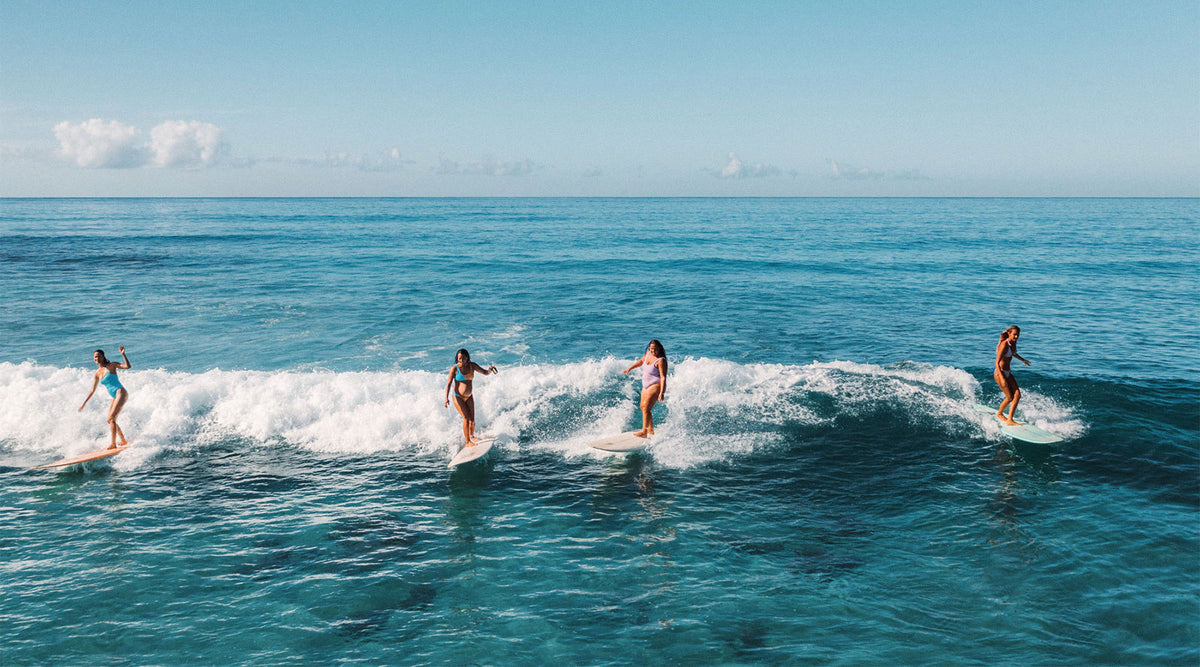 Girsl Surfing Together and Having Fun on the same wave