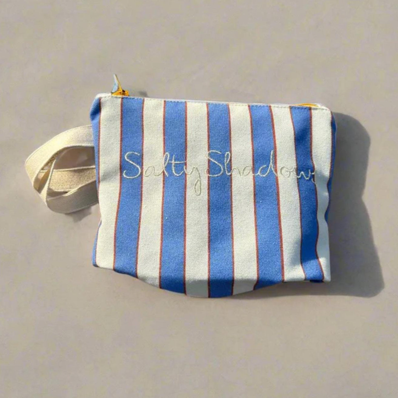 Blue and white striped pouch on a beige background