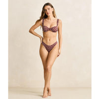 Woman wearing a polka dot bikini against a neutral background