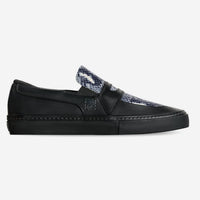 Black slip-on sneaker with snake print tongue on a white background