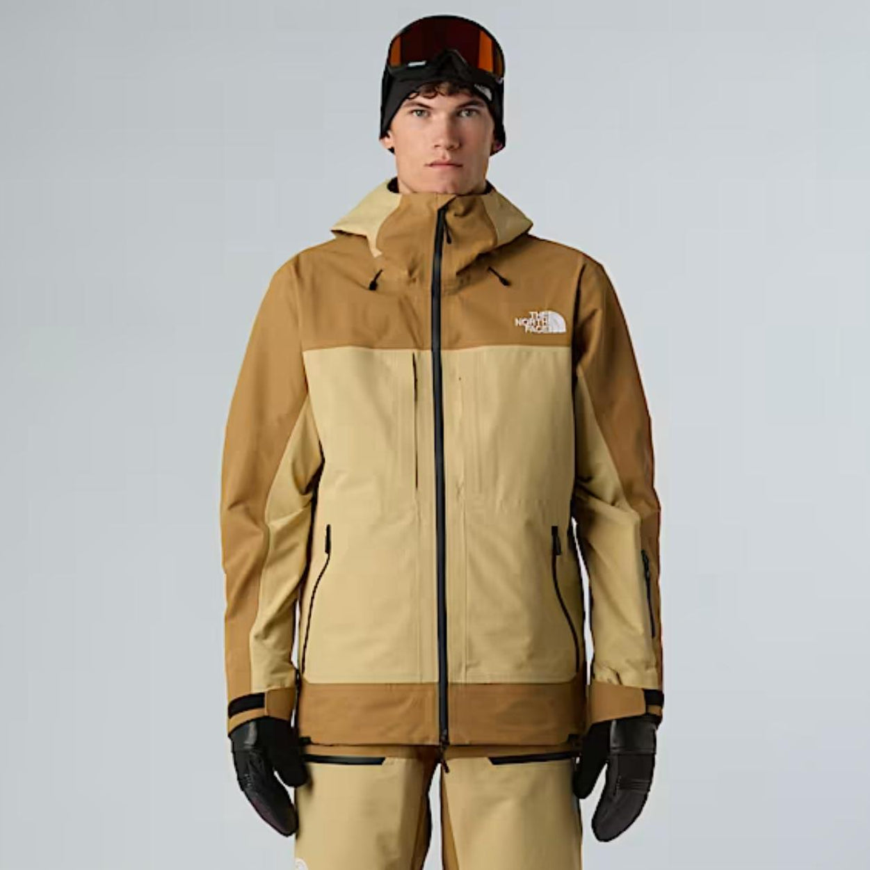 Person wearing a brown and beige snowsuit with The North Face logo on a gray background