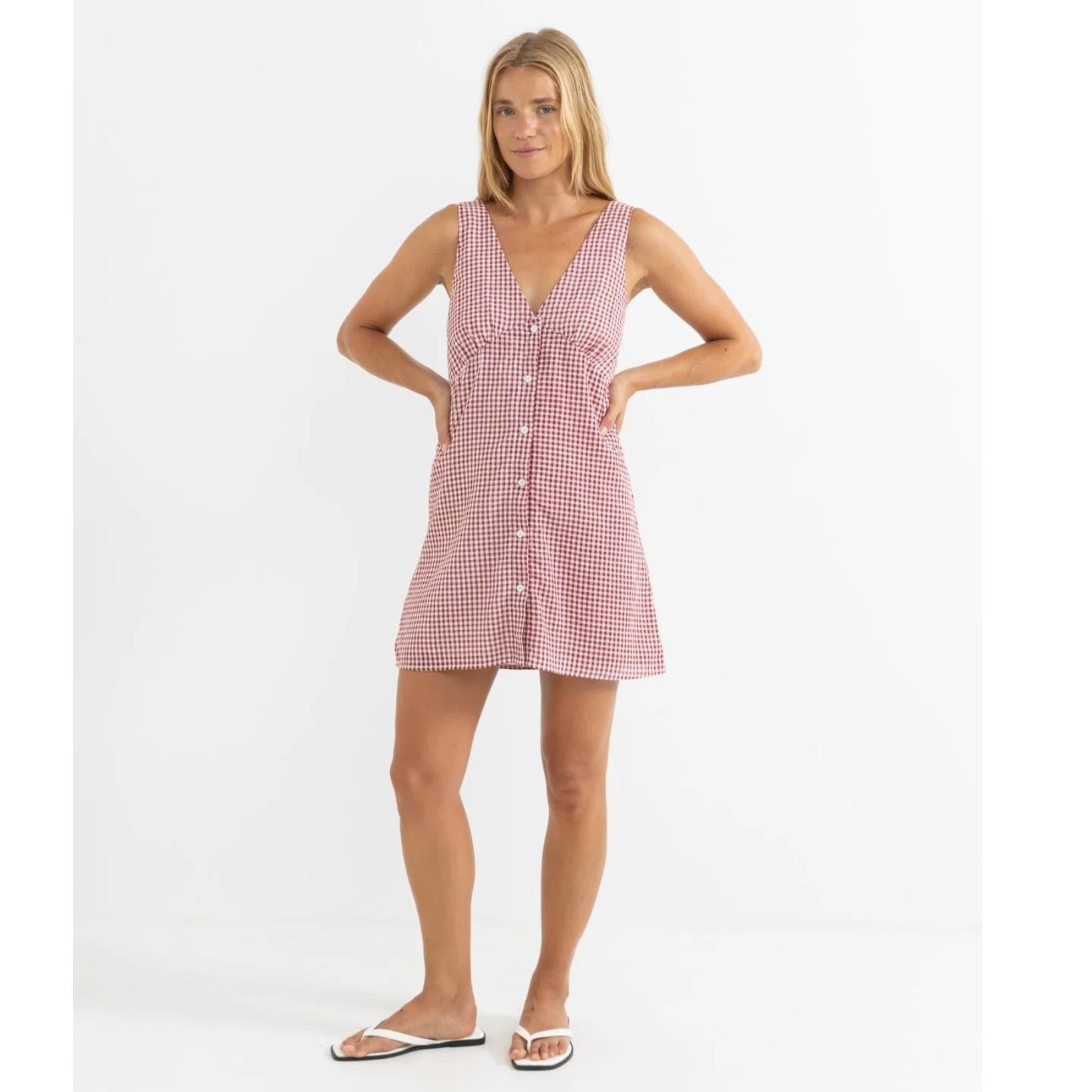 Woman wearing a pink checkered dress on a white background