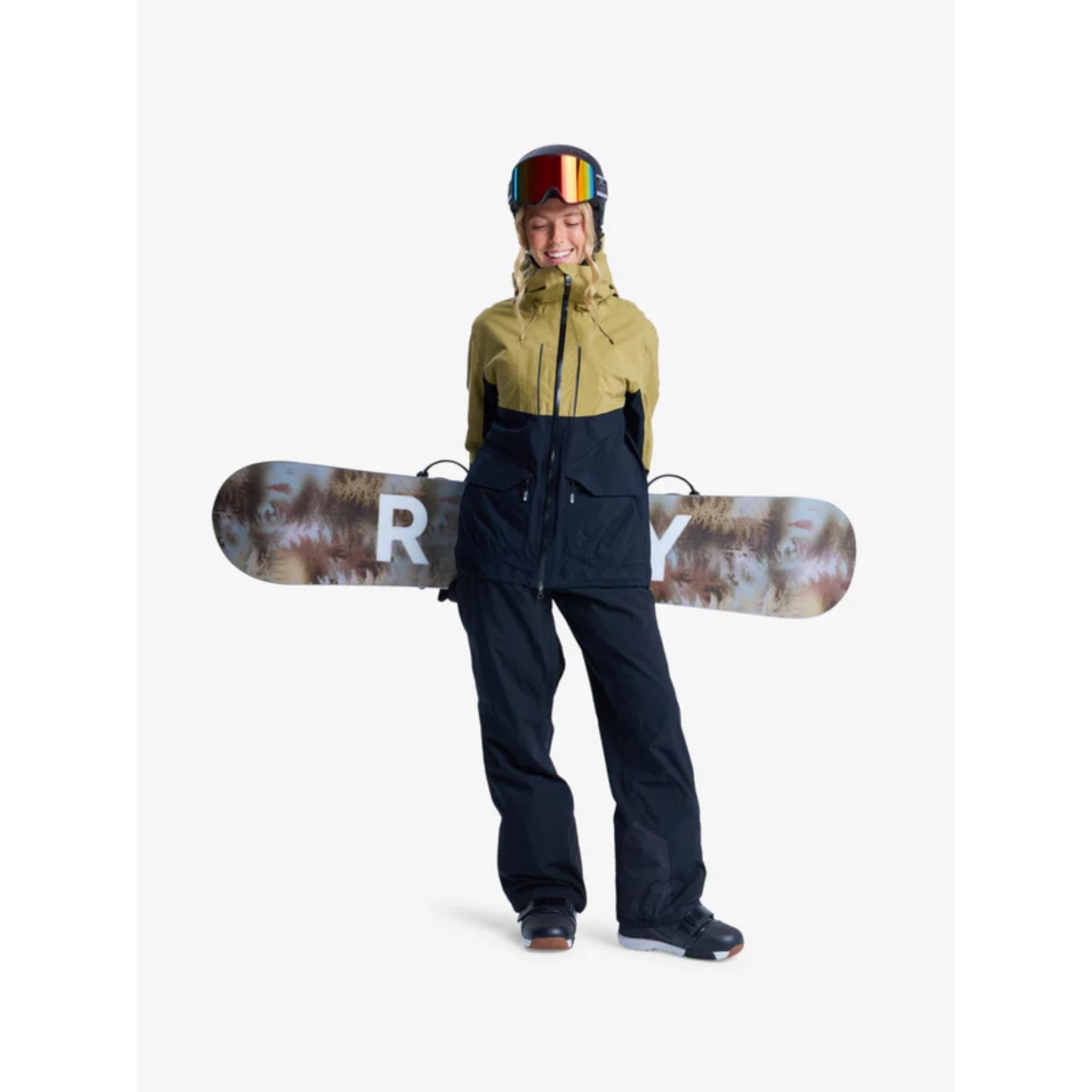 Person wearing a green jacket and black pants holding a snowboard with a visible brand logo on a white background