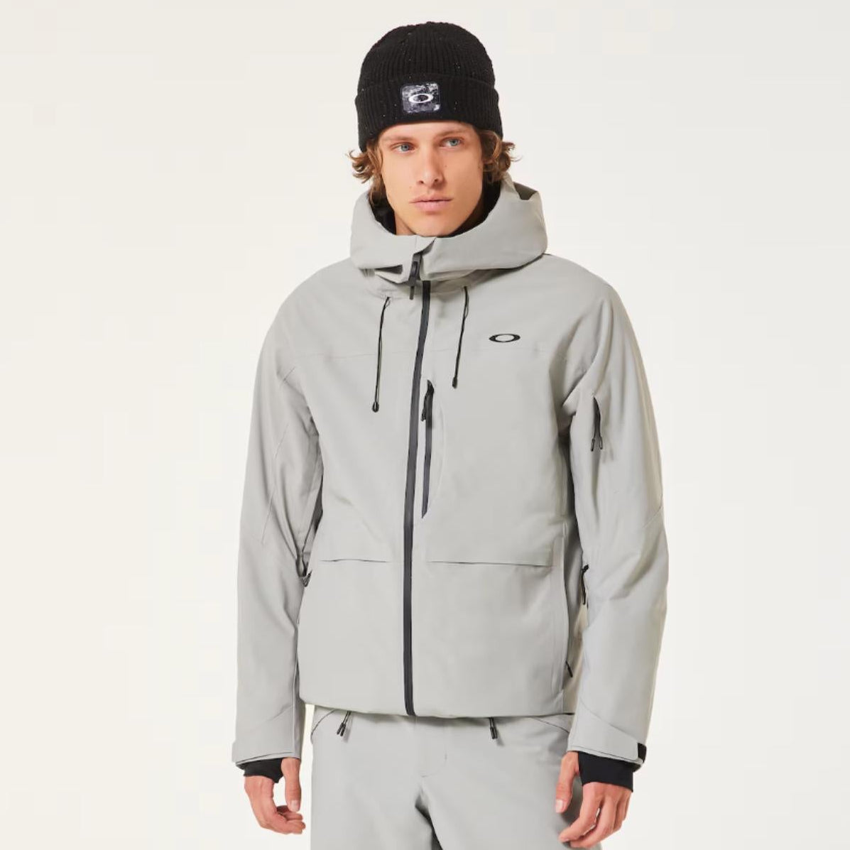 Person wearing a gray snowsuit with black boots on a white background