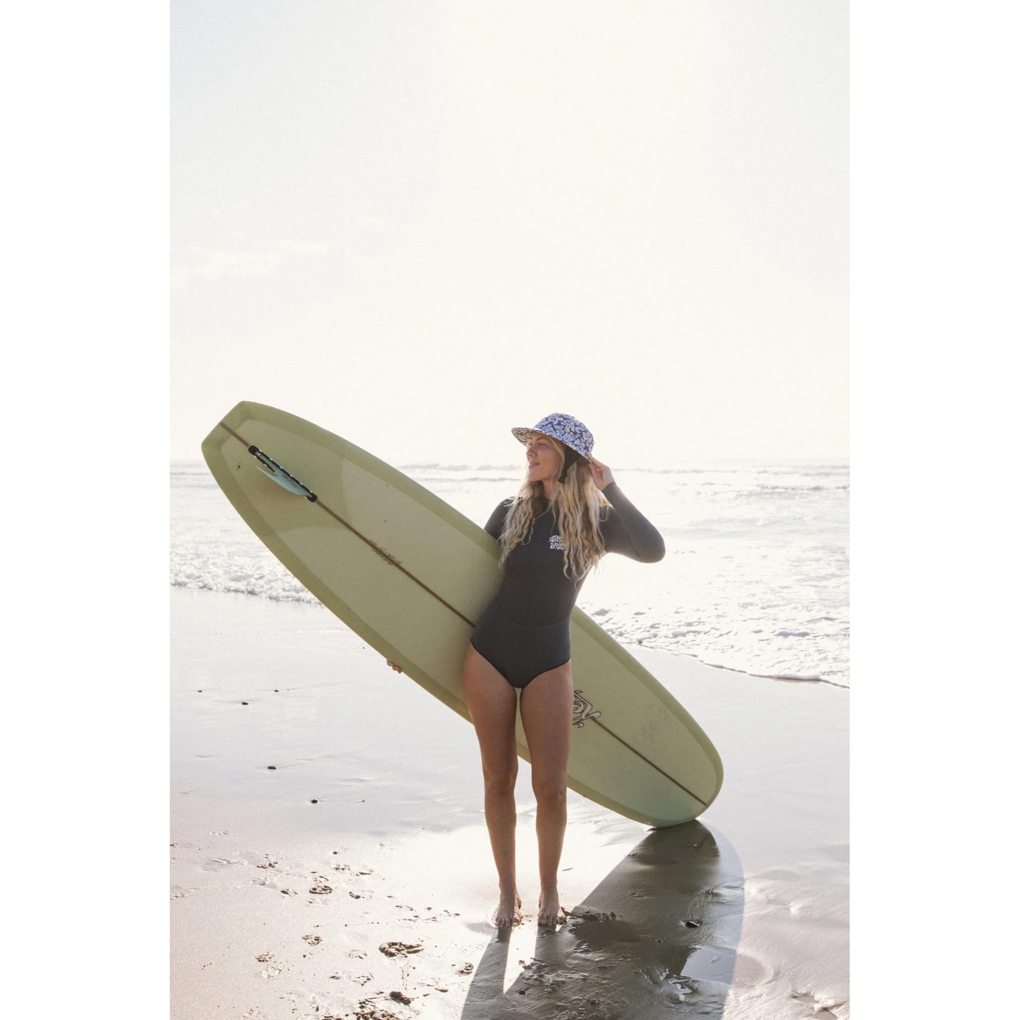 Woman holding a surfboard on a beach